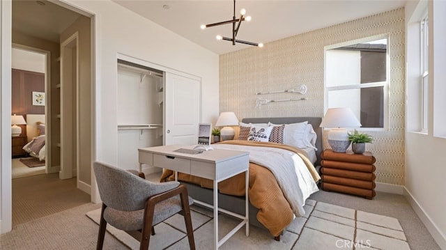 carpeted bedroom with an inviting chandelier and a closet