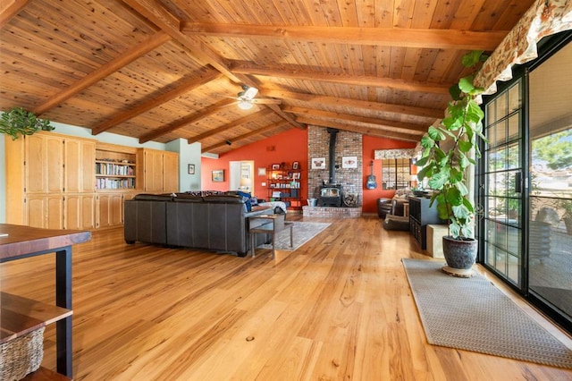 unfurnished living room with light hardwood / wood-style flooring, wooden ceiling, lofted ceiling with beams, and a wood stove