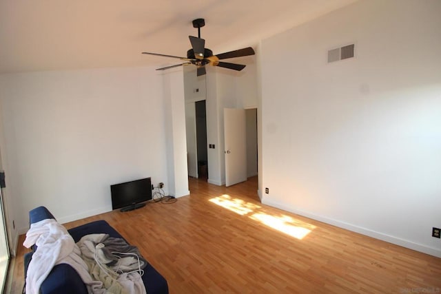 unfurnished living room with vaulted ceiling, ceiling fan, and light wood-type flooring