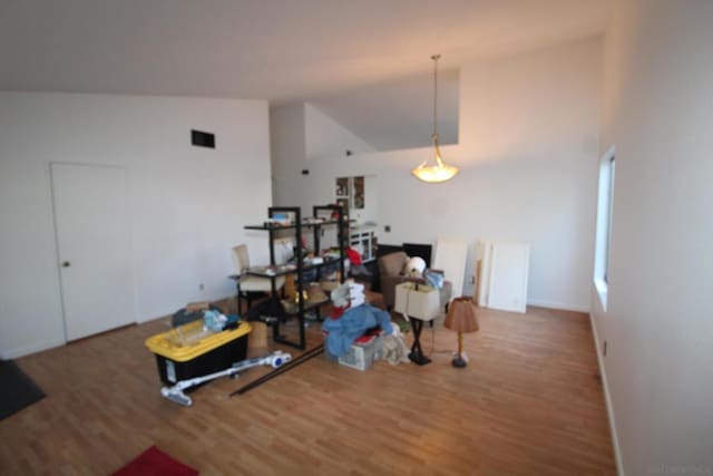 dining room with hardwood / wood-style flooring and high vaulted ceiling