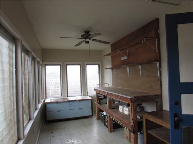 sunroom with ceiling fan and a workshop area