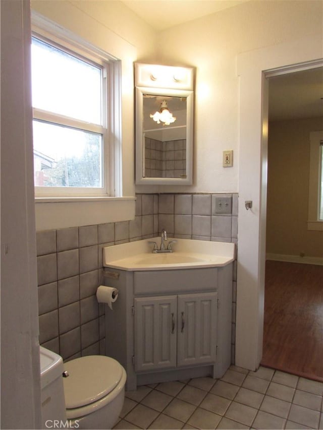 bathroom with tile walls, vanity, tile patterned floors, and toilet