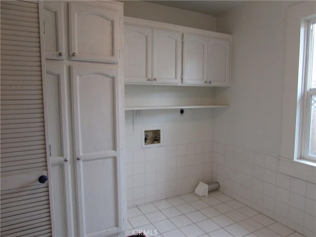 washroom featuring washer hookup, cabinets, light tile patterned floors, and hookup for an electric dryer