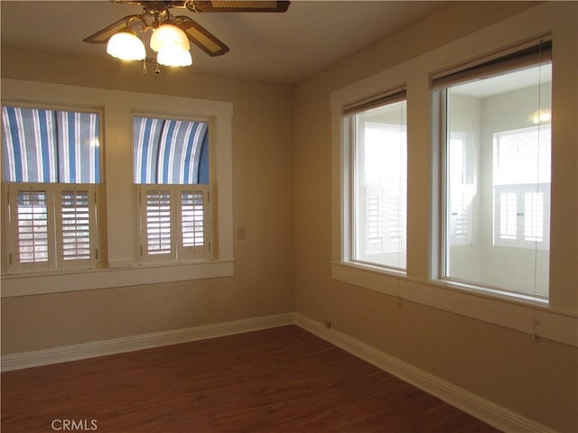 empty room with dark hardwood / wood-style floors and ceiling fan