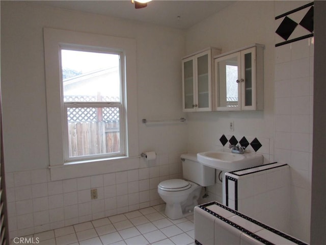 bathroom with tile walls, sink, tile patterned floors, and toilet