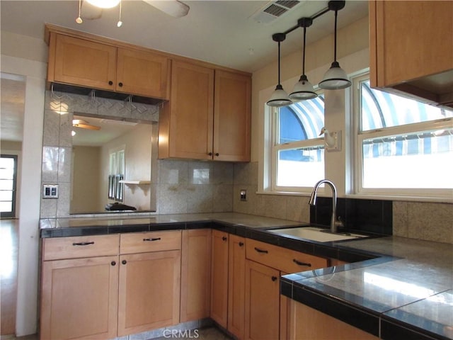 kitchen featuring tasteful backsplash, sink, tile counters, and ceiling fan