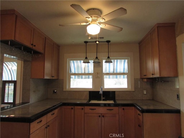 kitchen with hanging light fixtures, sink, ceiling fan, and decorative backsplash