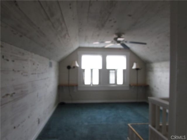 additional living space with wood ceiling, vaulted ceiling, and dark colored carpet