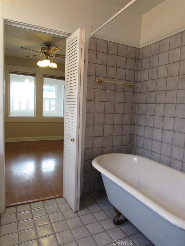 bathroom featuring tile walls, a bath, tile patterned floors, and ceiling fan