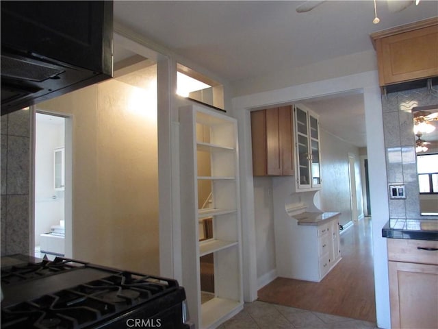 kitchen featuring light brown cabinetry, light tile patterned floors, black range with gas stovetop, and ceiling fan