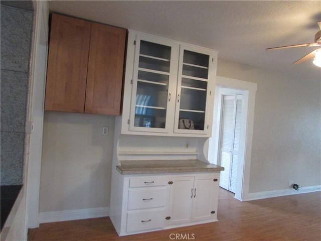 kitchen with ceiling fan, white cabinets, and light wood-type flooring