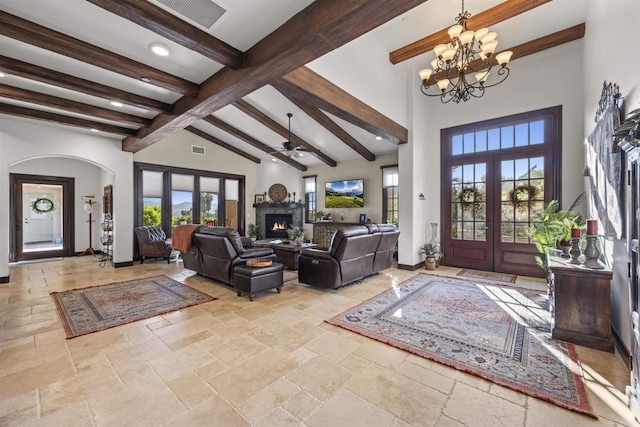 entrance foyer with beam ceiling, ceiling fan with notable chandelier, high vaulted ceiling, and french doors