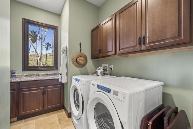 clothes washing area featuring cabinets and washer and clothes dryer