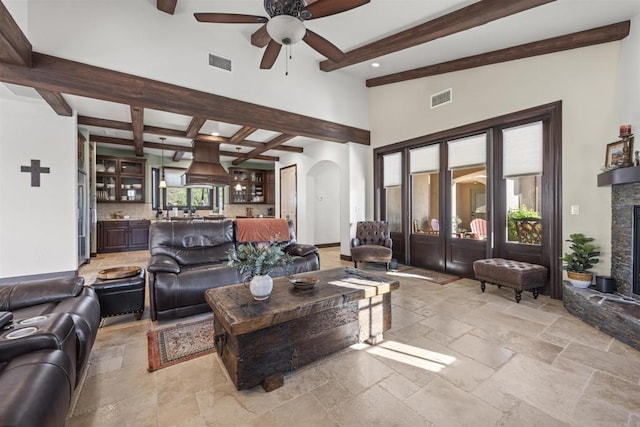 living room featuring beamed ceiling and ceiling fan