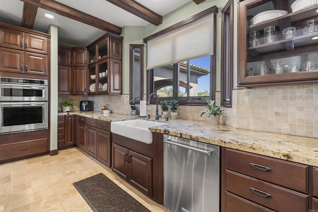 kitchen featuring beam ceiling, appliances with stainless steel finishes, sink, and dark brown cabinetry