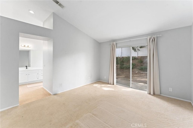 carpeted spare room with vaulted ceiling