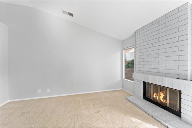 unfurnished living room with light colored carpet, lofted ceiling, and a brick fireplace