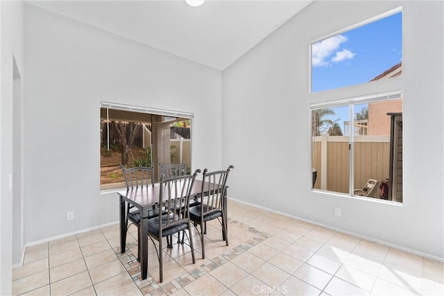 tiled dining space featuring high vaulted ceiling