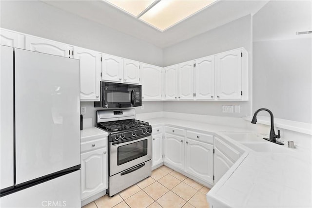 kitchen with stainless steel gas range oven, sink, and white cabinets