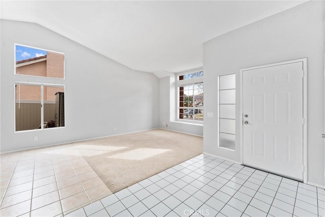 carpeted entrance foyer featuring lofted ceiling