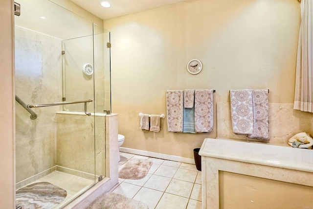 bathroom with tile patterned floors, toilet, and a shower with shower door