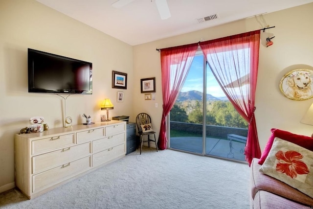 sitting room featuring a mountain view, light colored carpet, and ceiling fan