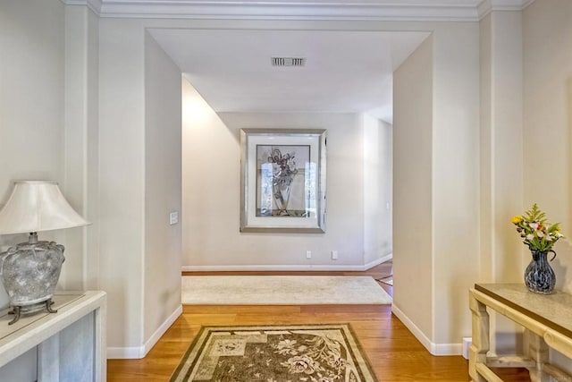 corridor featuring hardwood / wood-style flooring and ornamental molding