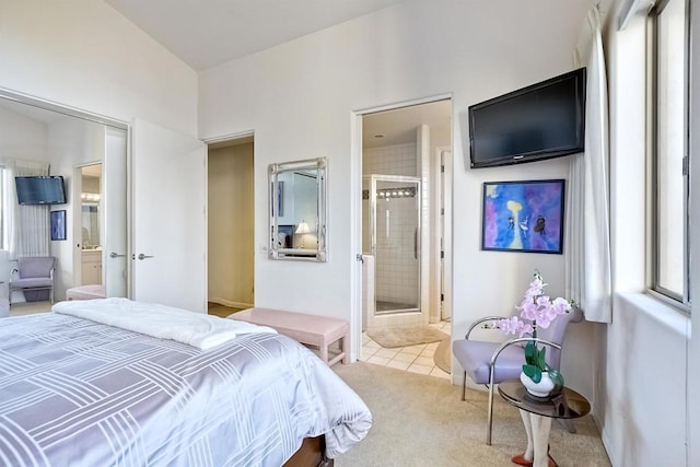 bedroom with ensuite bath and light colored carpet