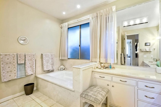 bathroom with tiled tub, vanity, and tile patterned floors