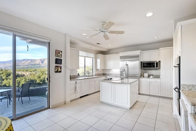 kitchen featuring a kitchen island, white cabinetry, a mountain view, and appliances with stainless steel finishes