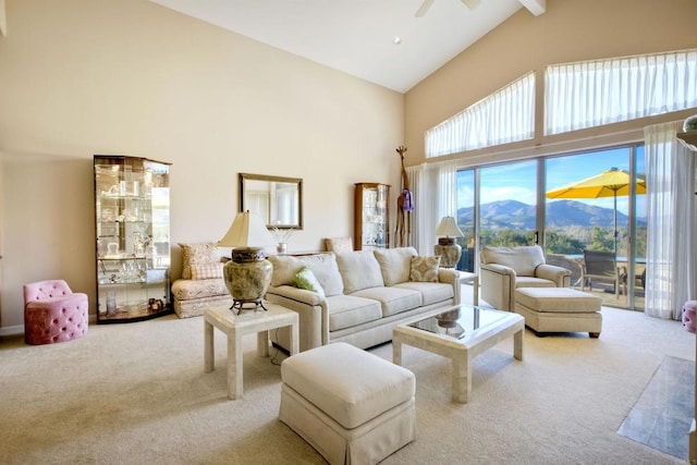 living room with ceiling fan, a mountain view, high vaulted ceiling, and light carpet