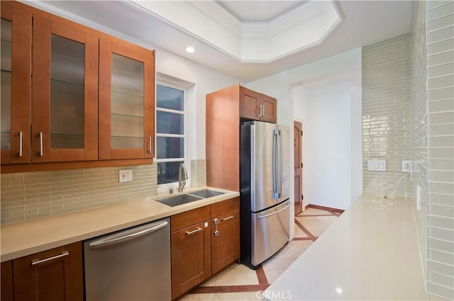 kitchen with appliances with stainless steel finishes, sink, and decorative backsplash