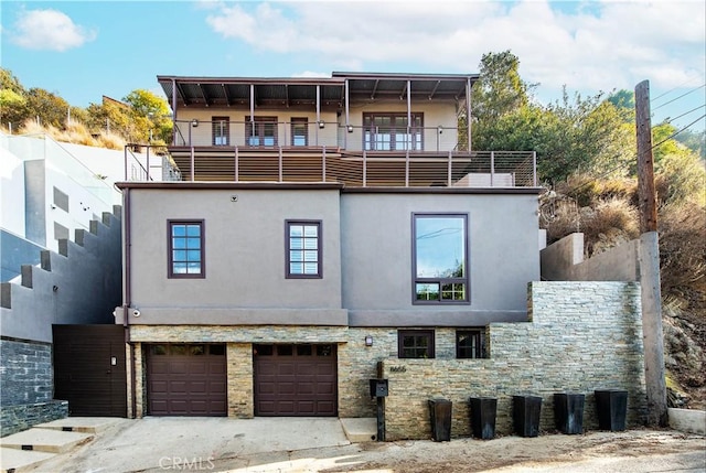 rear view of house with a balcony and a garage