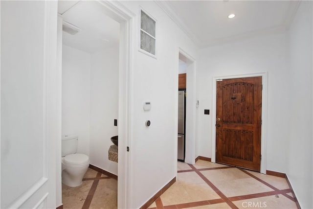 bathroom with ornamental molding and toilet