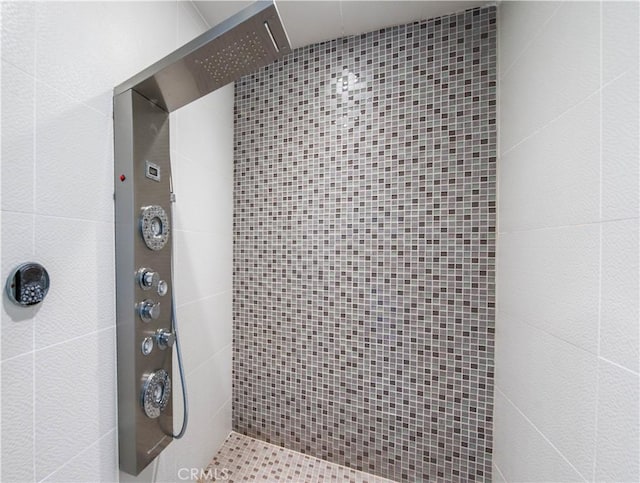 bathroom featuring elevator and a tile shower