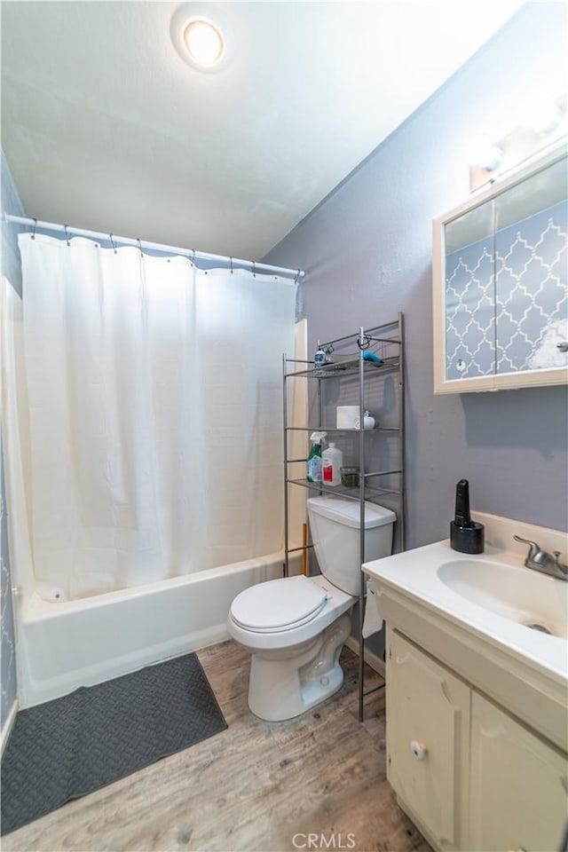 full bathroom featuring shower / bath combo with shower curtain, wood-type flooring, toilet, and vanity