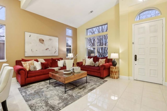 interior space featuring a healthy amount of sunlight, light tile patterned floors, and high vaulted ceiling