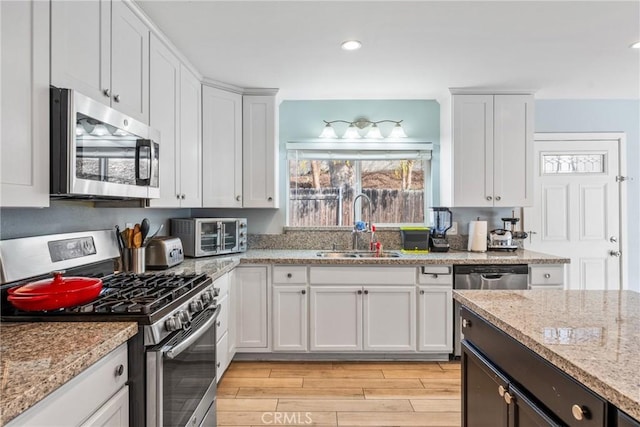 kitchen featuring appliances with stainless steel finishes, sink, and white cabinets