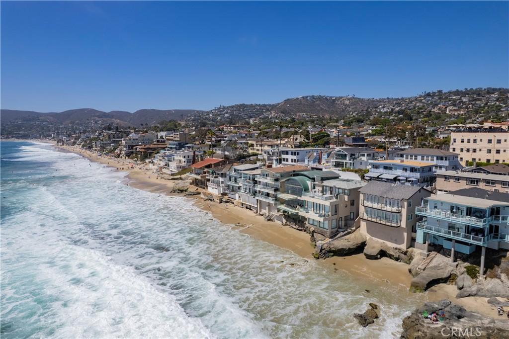 drone / aerial view featuring a view of the beach and a water and mountain view