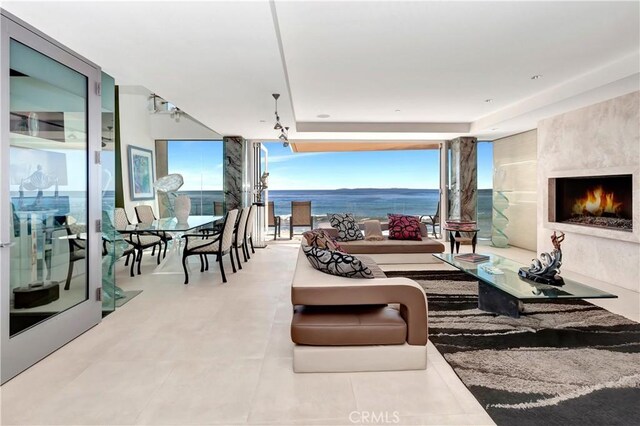 view of patio / terrace featuring a water view, a wall of windows, and a high end fireplace