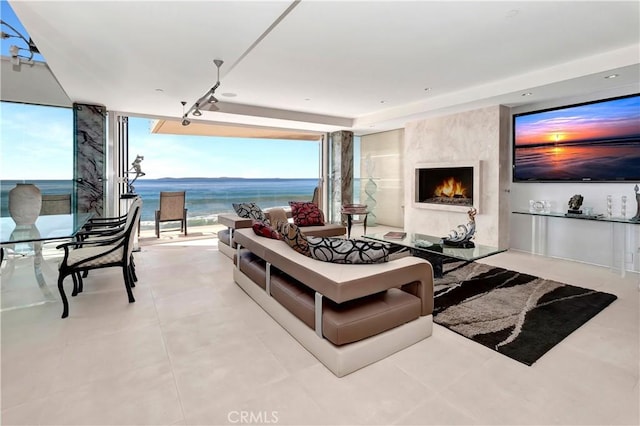 living room featuring a high end fireplace, light tile patterned floors, and a wall of windows