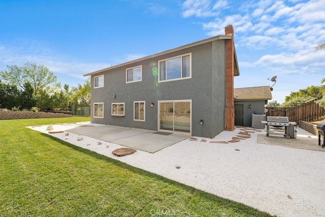 rear view of property featuring a patio area and a lawn