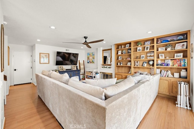 living room with ceiling fan and light wood-type flooring