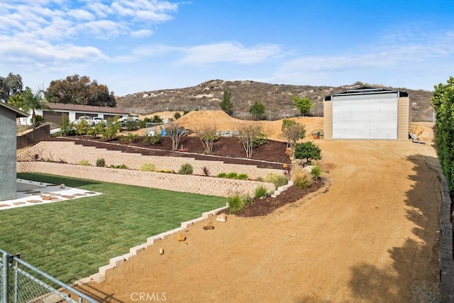 view of yard featuring a garage, an outdoor structure, and a mountain view