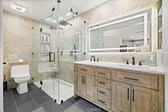 bathroom featuring tile walls, vanity, a shower with shower door, tile patterned floors, and toilet