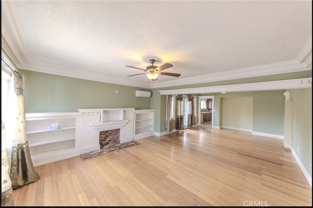 unfurnished living room with crown molding, a textured ceiling, ceiling fan, a fireplace, and light hardwood / wood-style floors