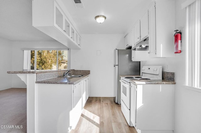 kitchen with white range with electric stovetop, white cabinetry, sink, a kitchen bar, and a healthy amount of sunlight