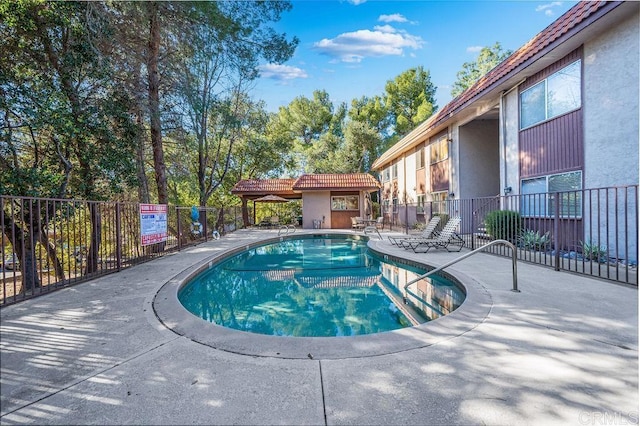 pool featuring fence and a patio