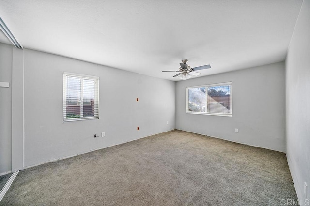 carpeted empty room featuring a ceiling fan