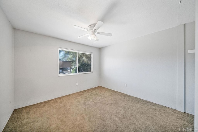 spare room with carpet floors and a ceiling fan